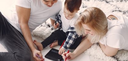 Parents and child enjoying drawing together on the floor, creating memories.